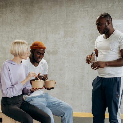 Three adults enjoy a nutritious meal together indoors, embracing a healthy lifestyle.