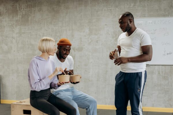 Three adults enjoy a nutritious meal together indoors, embracing a healthy lifestyle.