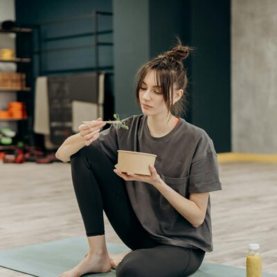 Young woman eating a healthy meal after a yoga workout at the gym.